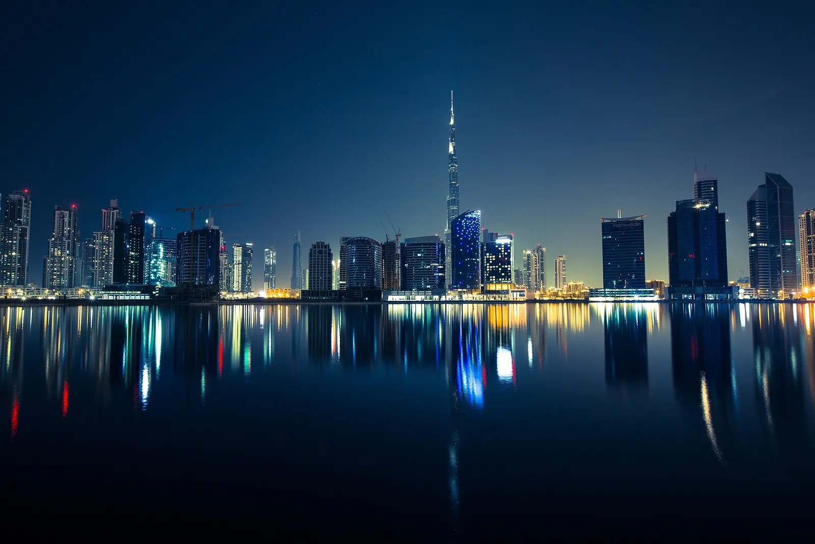Dubai skyline at night reflected in the water